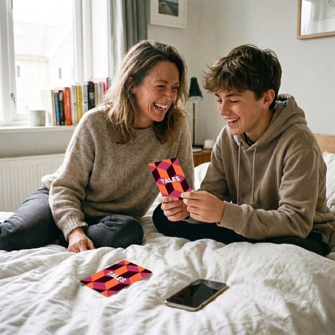 A mother and her teenage son using Tales cards together on the bed
